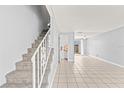 Open-concept living room showcasing tile floors and a staircase, perfect for modern living at 1600 S Palmetto Ave # 105, South Daytona, FL 32119