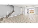 Spacious living room with tile flooring, adjacent to the staircase and kitchen area at 1600 S Palmetto Ave # 105, South Daytona, FL 32119