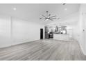 Open-concept living room with vaulted ceilings, a ceiling fan, and light wood flooring at 1626 Lansfield Ave, Deltona, FL 32738