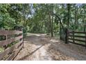 Gated entrance on a long private driveway surrounded by trees at 1690 S Adelle Ave, Deland, FL 32720