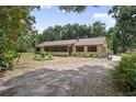 Charming single-story home with lush landscaping and a long driveway at 1690 S Adelle Ave, Deland, FL 32720