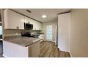 Bright kitchen boasts stainless steel appliances, granite countertops, and sleek white cabinets at 175 Center St, Daytona Beach, FL 32117