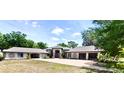 Expansive single-story home featuring two garages, a horseshoe driveway and tropical landscaping at 183 Mcgregor Rd, Deland, FL 32720
