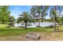 Backyard view of lake with two small boats on the grass near the dock and a small fire pit at 1862 Shelby Ter, Deltona, FL 32725