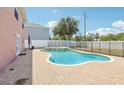 View of the pool and surrounding brick patio, with a safety fence and the exterior of the house at 193 Fish Hawk Dr, Winter Haven, FL 33884