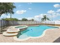 The backyard shows a pristine pool and spa combo, framed by a brick patio and a secure safety fence at 193 Fish Hawk Dr, Winter Haven, FL 33884