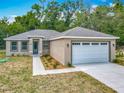 Attractive single-story house showcases a gray roof, stone accents, and a driveway leading to an attached garage at 200 S Montgomery Ave, Deland, FL 32720