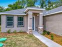 Inviting front entry with stone pillars, a modern front door, and fresh landscaping at 200 S Montgomery Ave, Deland, FL 32720