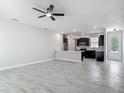 Open-concept living area with tile flooring and a view of the kitchen featuring dark wood cabinets at 200 S Montgomery Ave, Deland, FL 32720