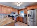 Updated kitchen featuring granite countertops, stainless steel appliances, and wood cabinetry at 2213 Needle Palm Dr, Edgewater, FL 32141