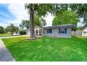 Beautiful one-story home boasting lush green lawn, mature shade trees, attached garage, and inviting front porch at 2254 Green St, South Daytona, FL 32119