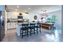 Bright kitchen with white cabinets, granite countertops, island, and adjacent dining area at 258 Sandoval Dr, Ormond Beach, FL 32174