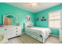 Bright bedroom with white furniture, a ceiling fan, a window, and an eye-catching accent wall at 2672 Star Coral Ln, New Smyrna Beach, FL 32168