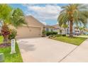 The lovely exterior of the home features an attached two-car garage and a well-maintained lawn and landscaping at 2672 Star Coral Ln, New Smyrna Beach, FL 32168