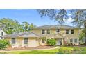 Two-story home with a manicured front yard and mature trees at 28 Shadowcreek Way, Ormond Beach, FL 32174