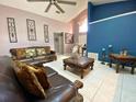 Spacious living room featuring high ceilings, tile flooring, and elegant leather furniture at 2953 Autumn Run Pl, Orlando, FL 32822
