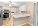 Well-lit kitchen with white cabinets, stainless steel appliances, and a mosaic tile backsplash at 333 Redwood Ave, Orange City, FL 32763