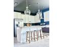 Bright, open kitchen featuring a large island, stainless appliances, and modern pendant lighting at 4133 Gilford Cir, Ormond Beach, FL 32174