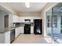 Bright kitchen featuring white cabinets, granite countertops, stainless steel dishwasher, and a black gas range at 417 Victoria Hills Dr, Deland, FL 32724