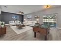 Spacious living room with ceiling fan, sliding glass doors to pool, and modern furniture arrangement at 486 Sycamore Springs St, Debary, FL 32713