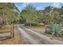 Long paved driveway leading to a private estate with mature trees and landscaping at 5265 Myakka Rd, De Leon Springs, FL 32130