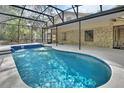 Inviting screened-in pool area with blue tile accents and comfortable outdoor space at 5265 Myakka Rd, De Leon Springs, FL 32130