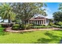Charming home surrounded by manicured landscaping, brick walkways, mature trees, and lush green lawn for a welcoming appeal at 5549 Aragon Ave, De Leon Springs, FL 32130