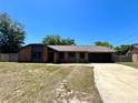 Charming one-story brick home featuring an attached garage and well-manicured lawn under a bright blue sky at 600 S Parkview Ave, Orange City, FL 32763