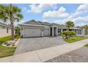 Charming single-story home featuring a three-car garage, beautiful landscaping, and a stone driveway at 660 Mosaic Blvd, Daytona Beach, FL 32124