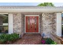 Close-up of front entrance with double doors, brick walkway, and manicured landscaping, showcasing welcoming curb appeal at 68 Spring Lake Dr, Debary, FL 32713