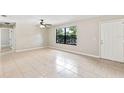 Bright living room with tile flooring, a ceiling fan, and a large window offering ample natural light at 688 Cumberland Rd, Deland, FL 32724