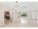Bright living room adjacent to an open kitchen, featuring neutral walls, tile flooring and ceiling fan at 688 Cumberland Rd, Deland, FL 32724