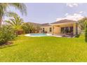 Private backyard features a pool, well-manicured lawn, and mature landscaping at 6917 Vintage Ln, Port Orange, FL 32128