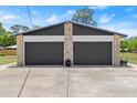Two car garage with black doors and stone accents at 793 Timothy St, Ormond Beach, FL 32174