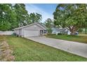 Single-story home with attached garage and a long driveway on a lush green lot at 941 Village Lake N Dr, Deland, FL 32724