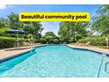 Beautiful community pool surrounded by mature landscaping, lounge chairs, and umbrella seating area at 979 Leyburn Dr, Deltona, FL 32725