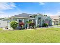 Well-manicured lawn and diverse landscaping complement this attractive single-story home at 979 Leyburn Dr, Deltona, FL 32725