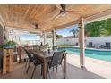 Outdoor patio with dining and seating areas overlooks a sparkling pool and fenced backyard at 1020 Hornbeam St, Oviedo, FL 32765