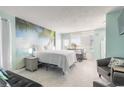 Bright, updated bedroom with a queen bed, palm tree wall art, and views of the ocean at 1233 N Atlantic Ave # 3090, Daytona Beach, FL 32118