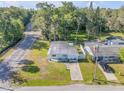 Aerial view of a charming home with a green lawn, next to a quiet residential street at 128 Oakridge Ave, Edgewater, FL 32132