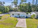 Bright one-story home with a well-maintained lawn, driveway, and partial fencing at 128 Oakridge Ave, Edgewater, FL 32132