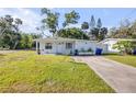 Inviting one-story home with a spacious green lawn and extended driveway at 128 Oakridge Ave, Edgewater, FL 32132