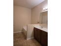 Bright bathroom featuring a soaking tub and vanity with wood cabinets at 139 Crawl Key Ct, Deland, FL 32720
