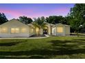 Charming home featuring well-manicured lawn and attractive blue double-door entrance, complemented by lush landscaping at 1523 Red Plum Holw, Deland, FL 32720