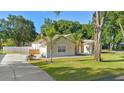 Bright home with a well-kept lawn, complemented by a lush tropical palm tree and a circular driveway at 1523 Red Plum Holw, Deland, FL 32720