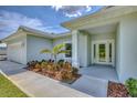 Inviting front entrance with double glass doors and a well-landscaped garden at 156 N Cory Dr, Edgewater, FL 32141