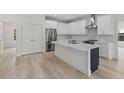 Modern kitchen features stainless appliances, white cabinets, and a central island at 156 N Cory Dr, Edgewater, FL 32141