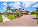 Spacious home with a tile roof, two-car garage, brick paver driveway, and meticulously manicured lawn at 163 Rosa Bella Vw, Debary, FL 32713