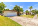 Single story home with a large driveway and front lawn under a blue sky at 1650 Jacobs Rd, South Daytona, FL 32119