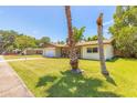 Well-kept lawn with a cozy single-story home, complimented by a large driveway and blue skies at 1650 Jacobs Rd, South Daytona, FL 32119